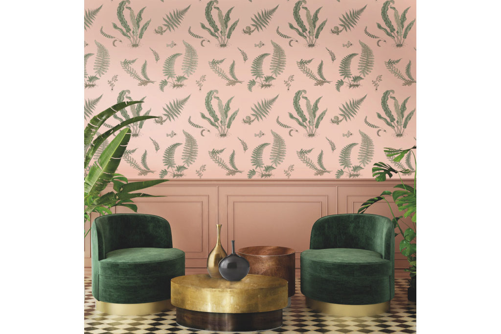 Blush pink wallpaper with ferns, green armchairs and gold side table