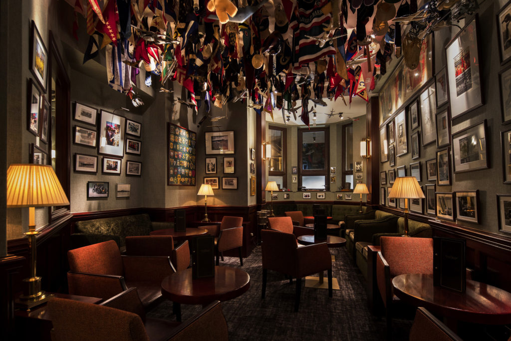 a dimly lit bar with american flags and lots of pictures on the walls