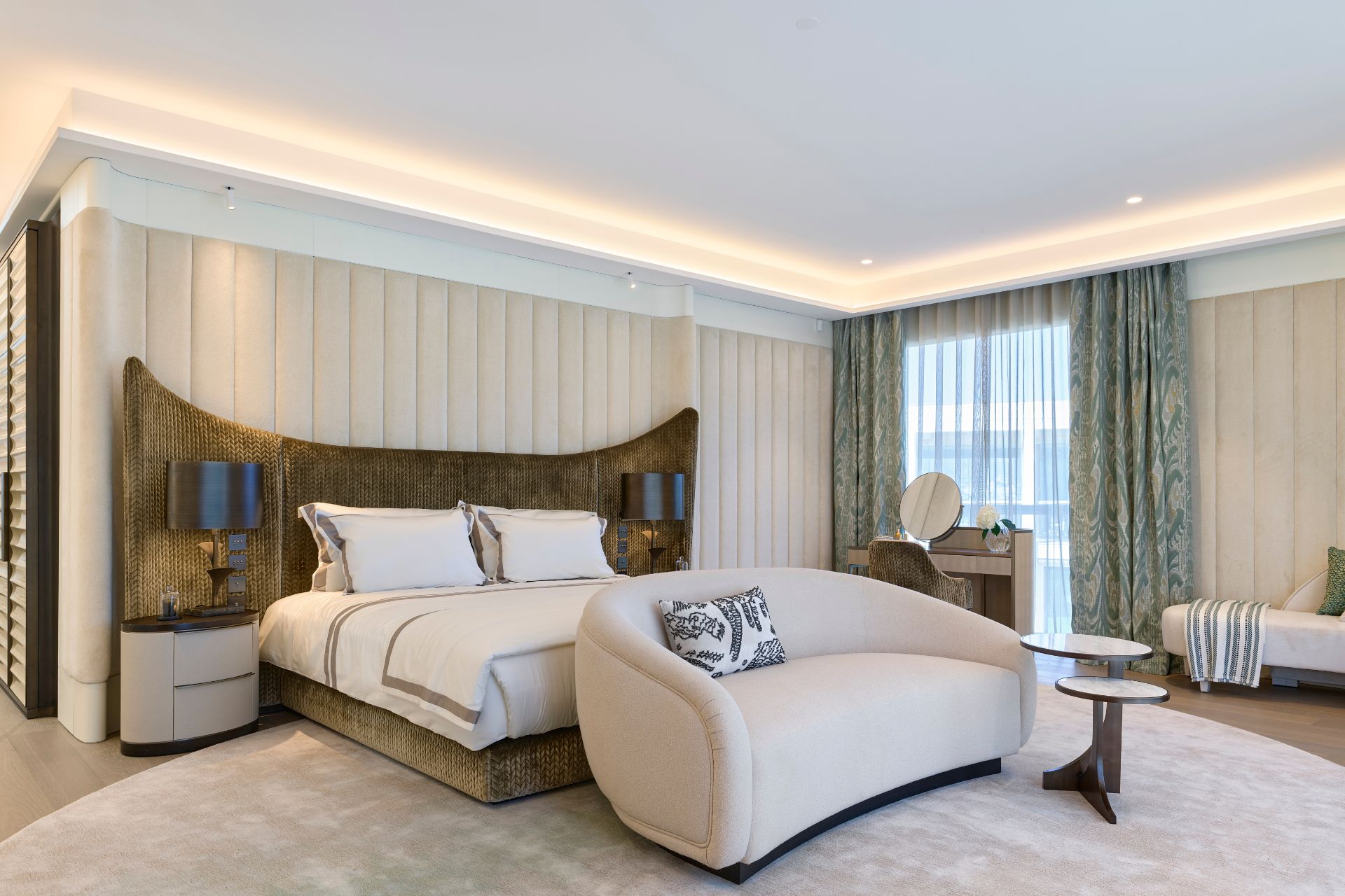 Bedroom with cream sofa and gold headboard