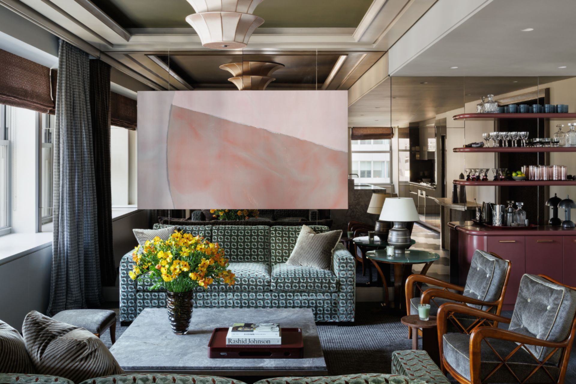 Living room with green and white patterned sofas, a bronze mural and a built-in bar